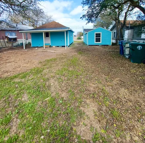a view of a yard in front of a house with large tree