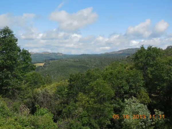 a view of a roof deck with table and chairs under an umbrella