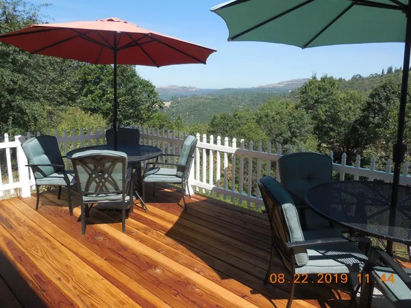 a view of balcony with wooden floor outdoor seating and yard