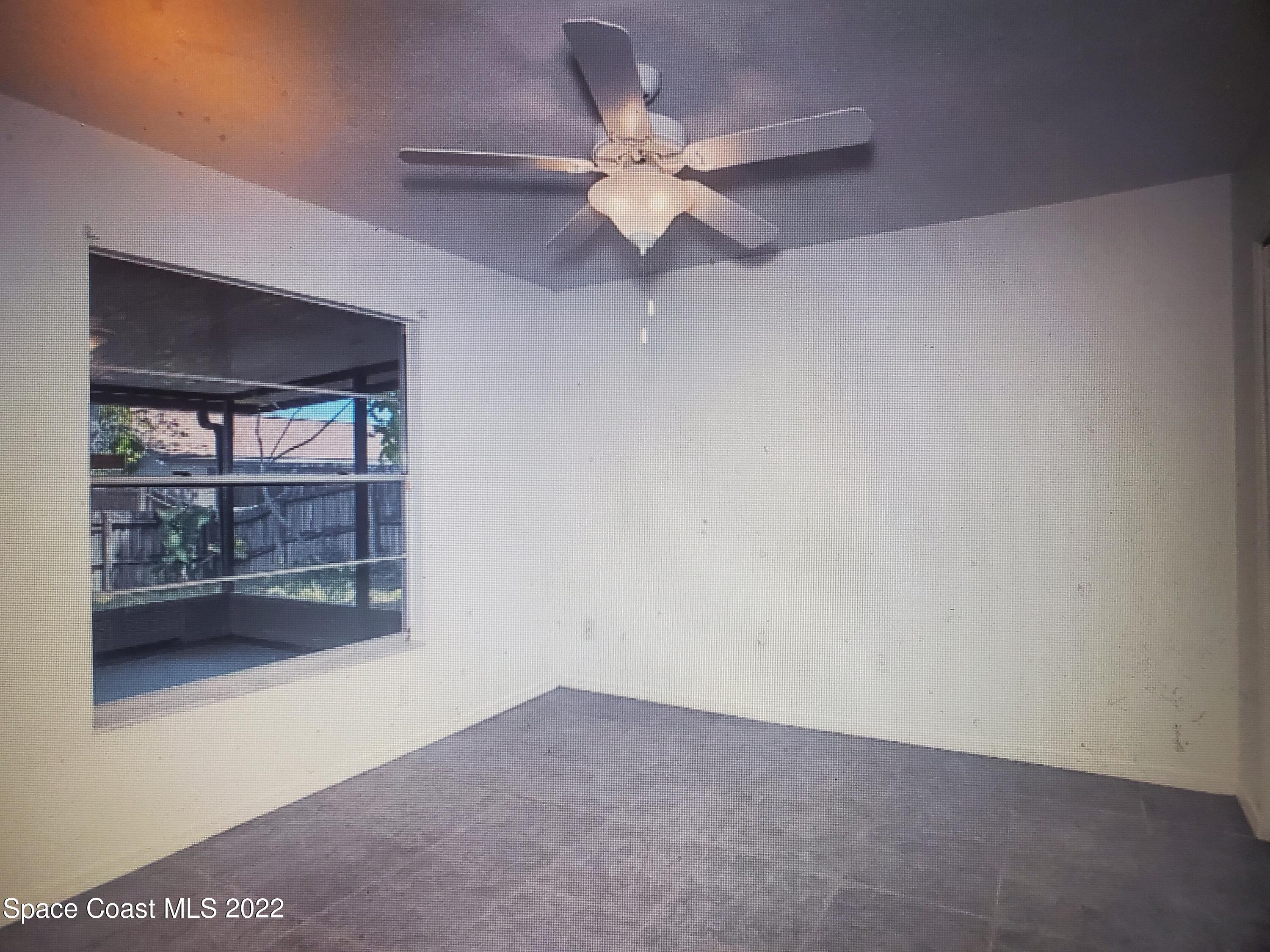 3716 Ranger Street Titusville, FL 32796 - Photo 4 of 7 an empty room with a ceiling fan and a window