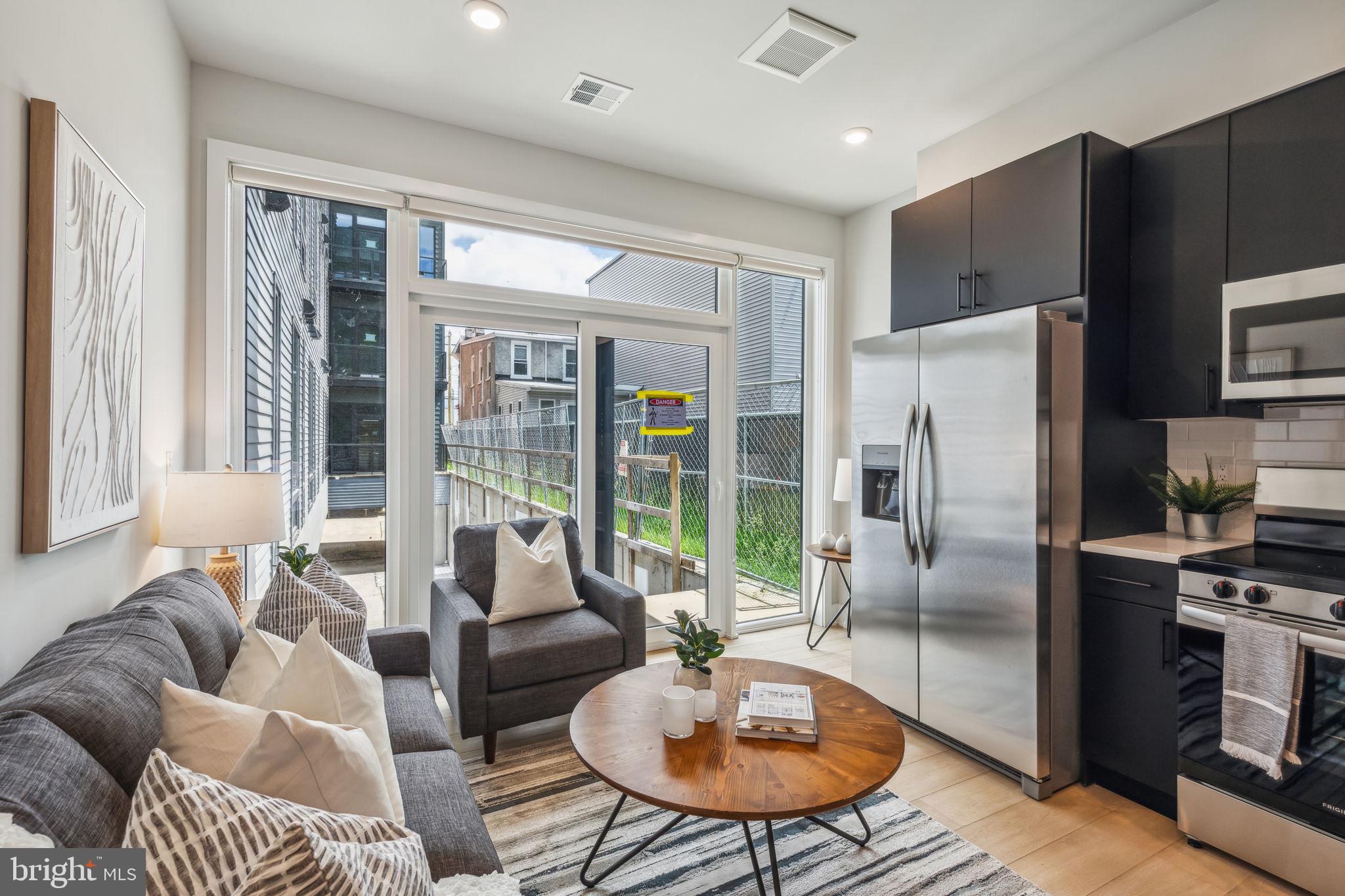 a living room with furniture a large window and a table