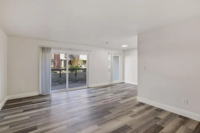 a view of a room with wooden floor and a window