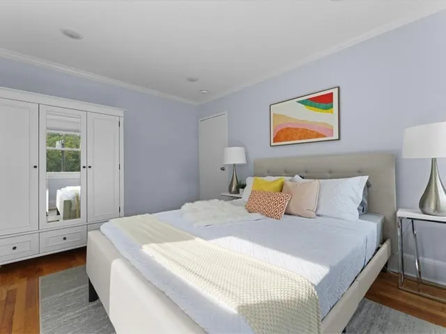 a bedroom with a bed and painting on the wall