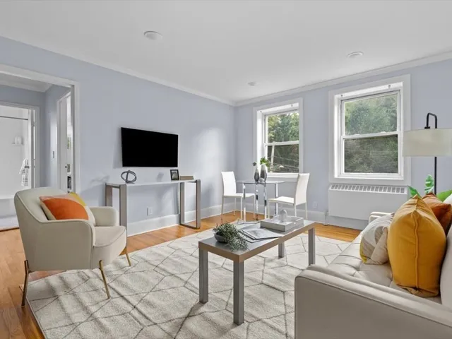 a living room with furniture a flat screen tv and a window