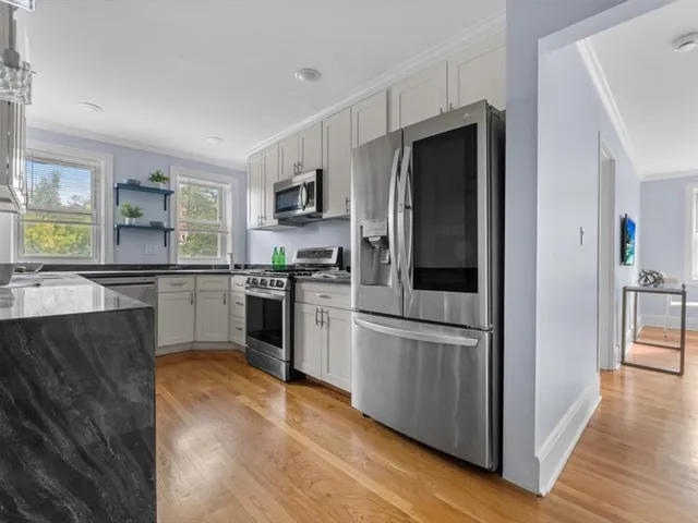 a kitchen with stainless steel appliances granite countertop a refrigerator and a stove top oven
