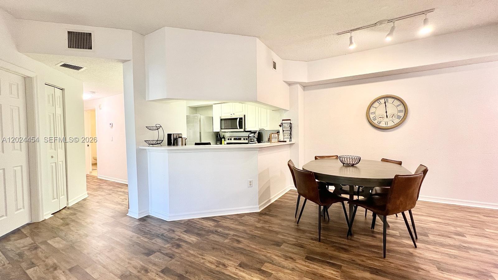 2727 Anzio Court, Unit 106 Palm Beach Gardens, FL 33410 - Photo 6 of 43 a view of a dining room with furniture and wooden floor