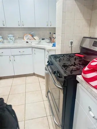 a kitchen with stainless steel appliances granite countertop a stove a sink and white cabinets