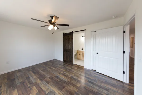 a view of a room with wooden floor and a ceiling fan