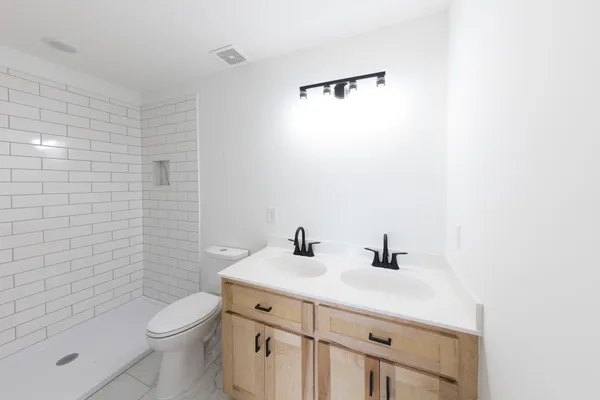 a bathroom with a sink a toilet and shower