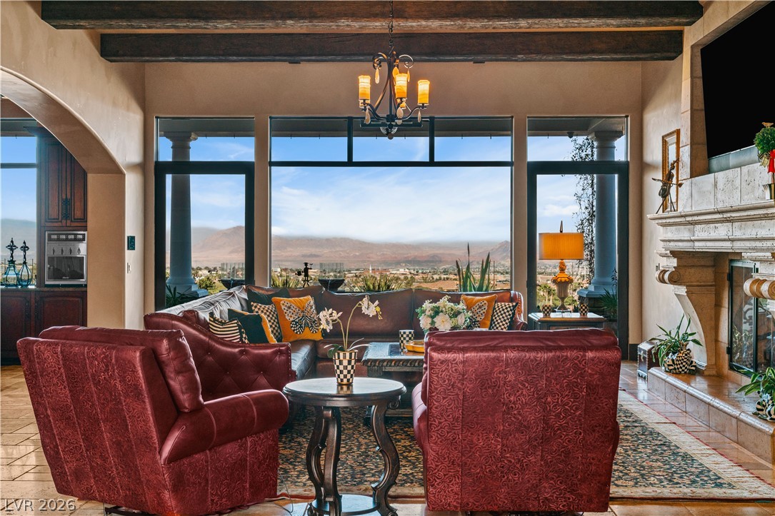 1123 Christian Road Henderson, NV 89002 - Photo 12 of 94 Natural light illuminates this living space, featuring a grand fireplace and panoramic mountain vistas.