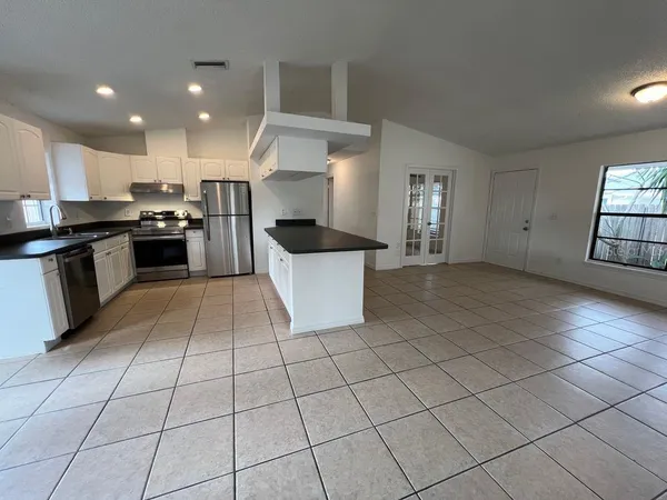 a large kitchen with a stove top oven and cabinets