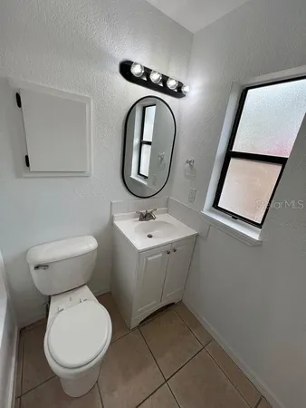 a bathroom with a toilet a sink and mirror