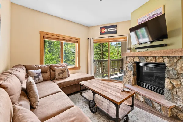 a living room with furniture a flat screen tv and a fireplace