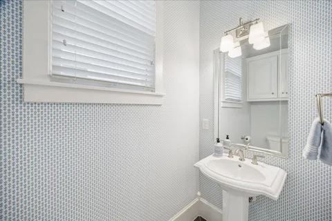 a bathroom with a sink a mirror and a toilet