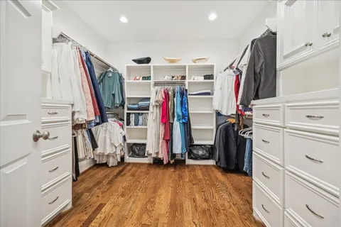 a view of walk in closet with clothes and shoes