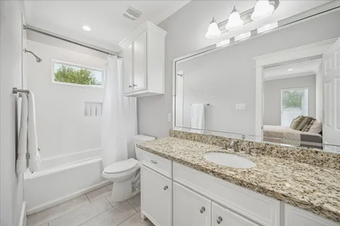 a bathroom with a granite countertop sink a toilet and bathtub