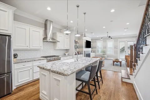 a kitchen with stainless steel appliances granite countertop wooden floor stove top oven and cabinets