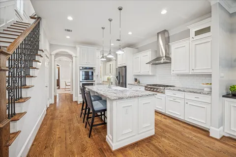 a kitchen with a table chairs wooden floors and a view of living room