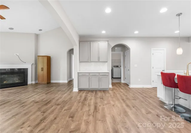 a view of a kitchen with wooden floor and a fireplace
