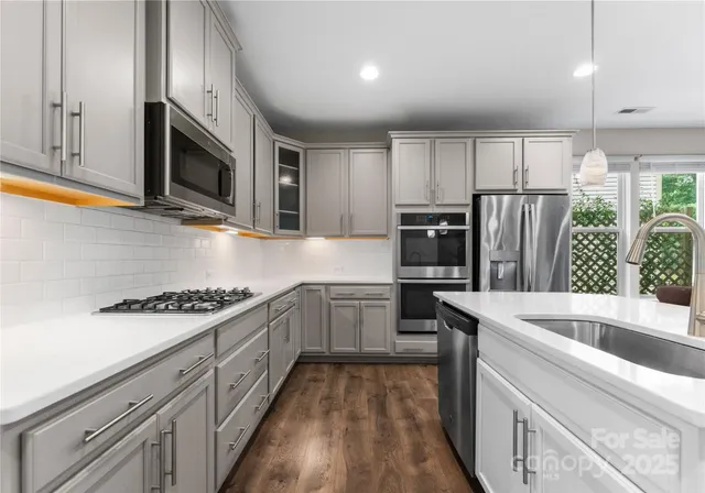 a kitchen with granite countertop a sink stainless steel appliances and cabinets