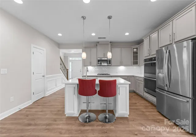 a kitchen with stainless steel appliances granite countertop a sink refrigerator and microwave