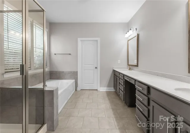 a spacious bathroom with a tub shower and sink