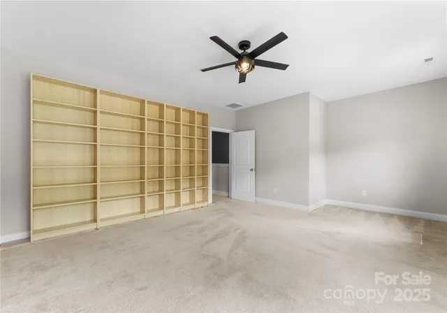 an empty room with a window and a ceiling fan