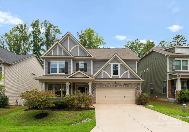 a view of a white house with a big yard and potted plants
