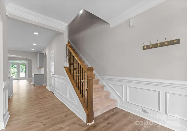 a view of a hallway with wooden floor and staircase