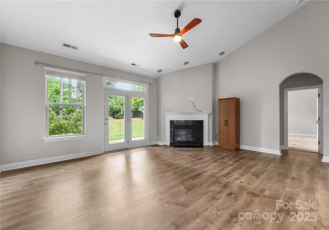 an empty room with windows and a fireplace