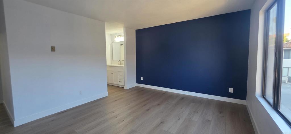 2306 Altisma Way, Unit 116 Carlsbad, CA 92009 - Photo 11 of 17 an empty room with wooden floor and windows