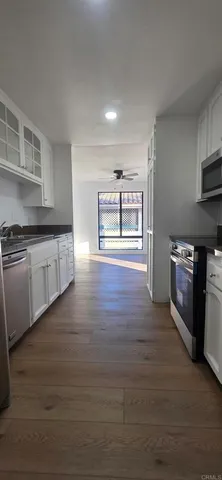 a kitchen with stainless steel appliances granite countertop a stove a sink and a wooden floors