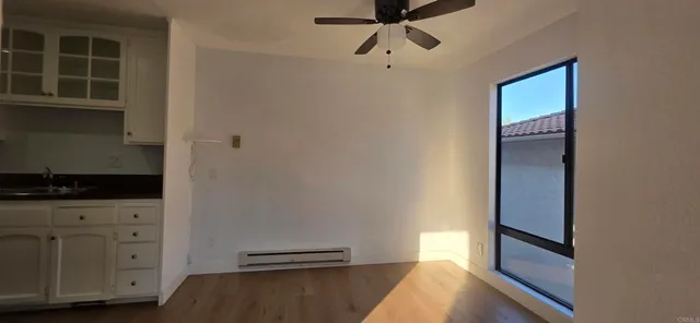 a view of a hallway with wooden floor and cabinets