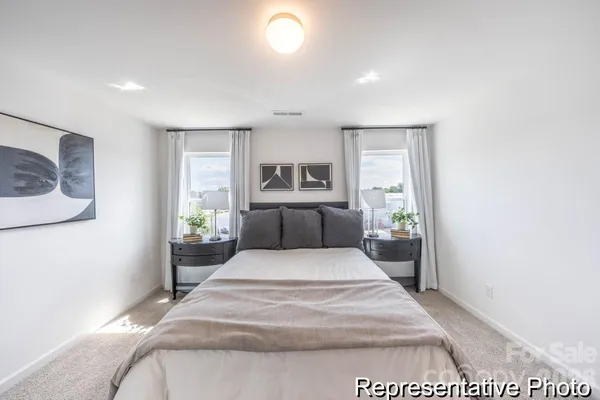 a large bedroom with a bed and wooden floor