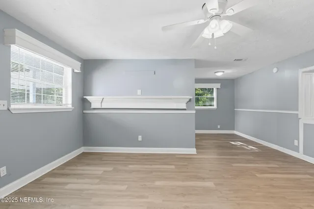 a view of a kitchen with wooden floor and windows in it