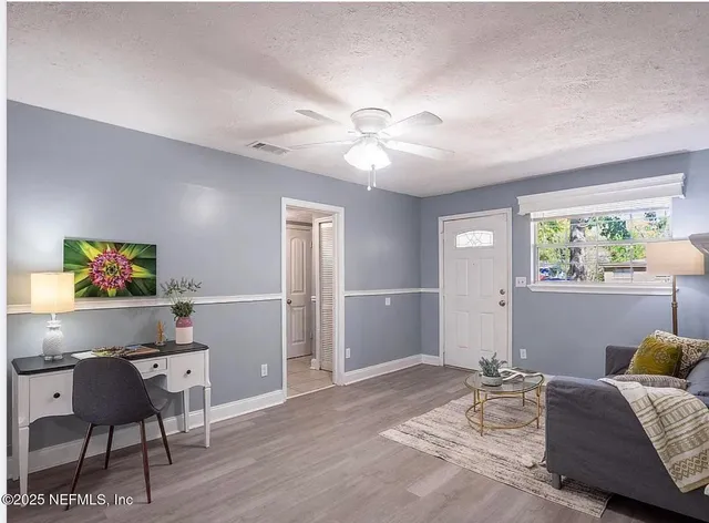 an empty room with fan and windows