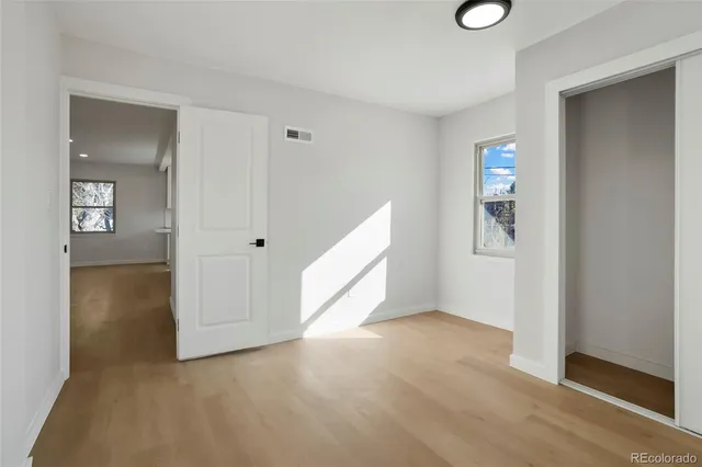 an empty room with windows and closet