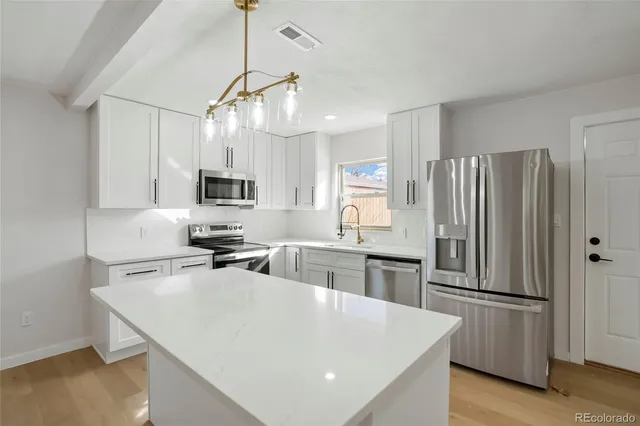 a kitchen with stainless steel appliances a refrigerator sink and microwave
