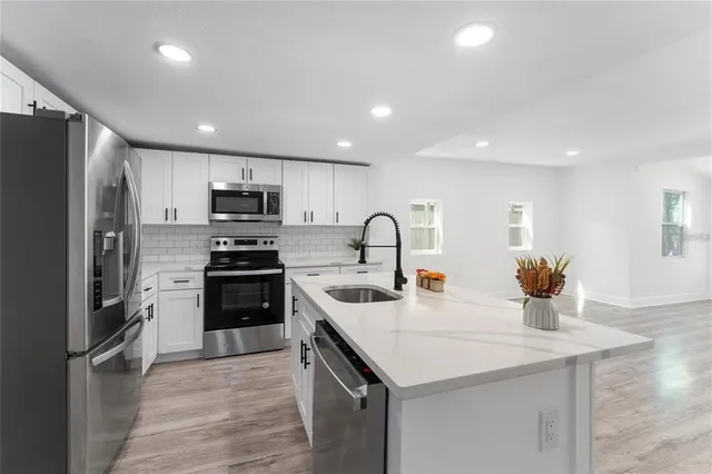 a kitchen with a sink stainless steel appliances and white cabinets