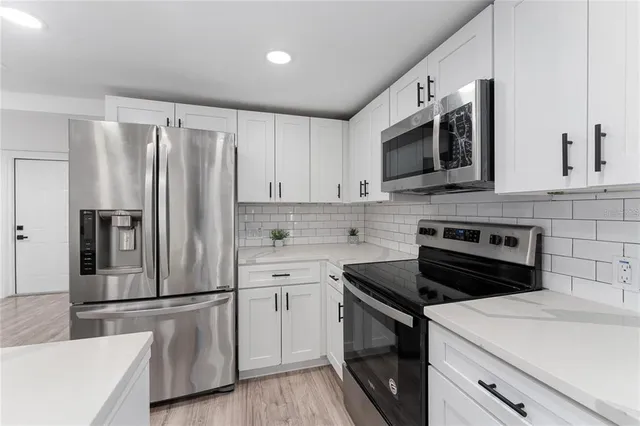 a kitchen with stainless steel appliances a refrigerator stove and sink