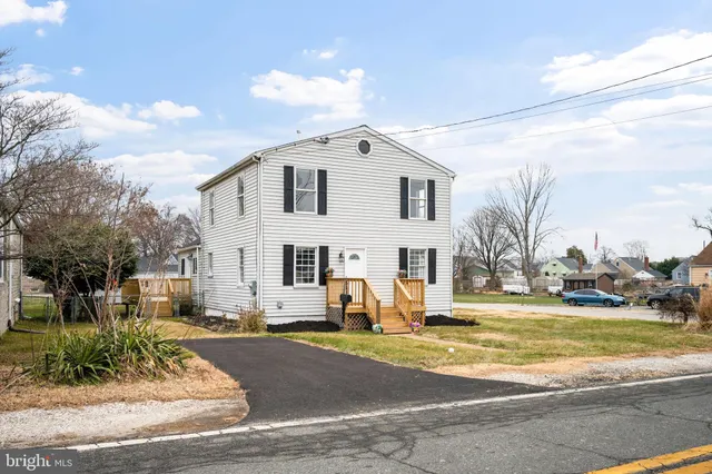 a view of a white house with a yard