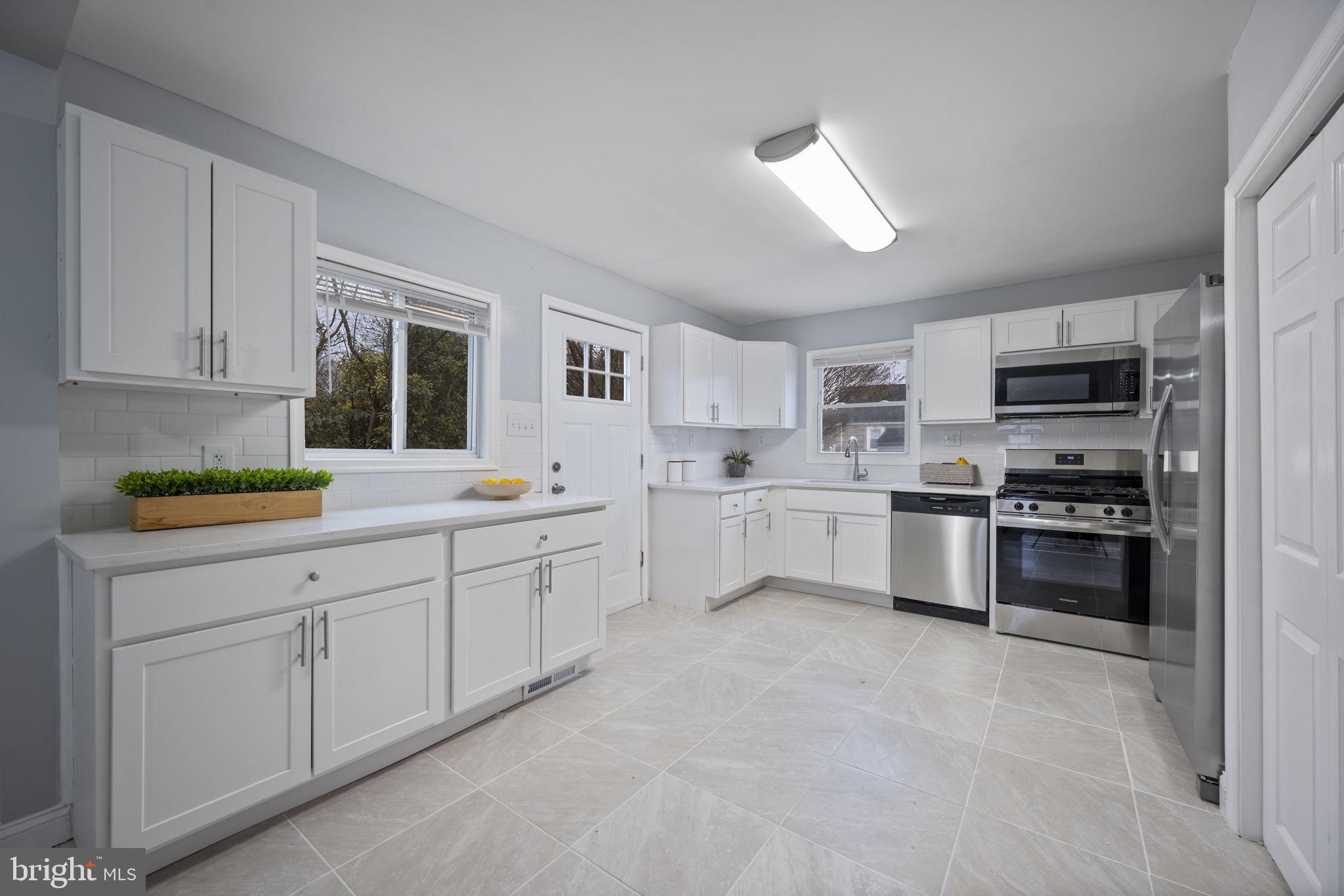 511 Riverside Drive Baltimore, MD 21221 - Photo 7 of 39 a kitchen with white cabinets and appliances