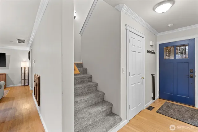 a view of a hallway with wooden floor and staircase