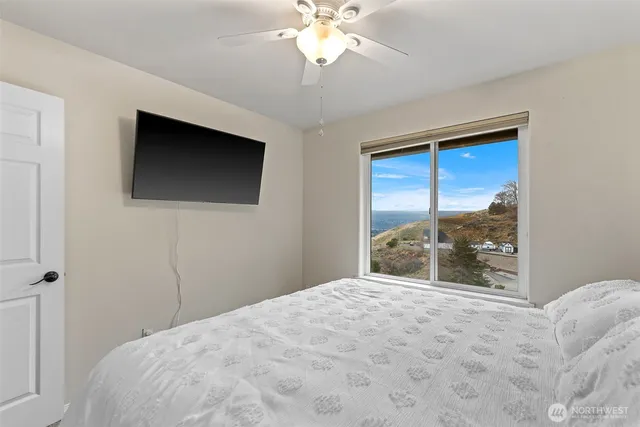 a bedroom with a bed and a large window