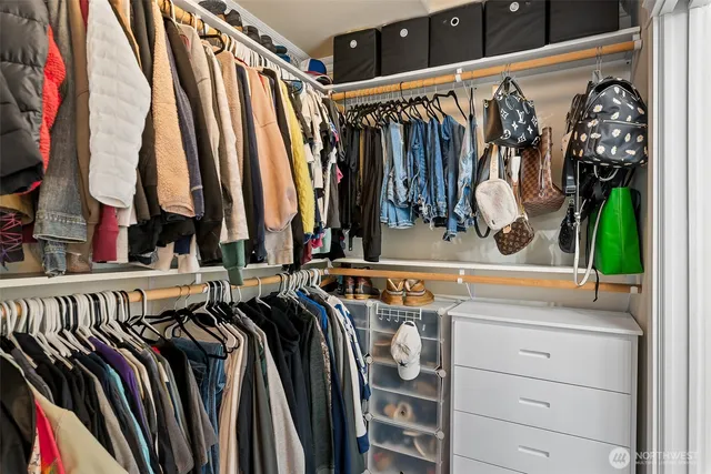 a view of walk in closet with clothes and shoes