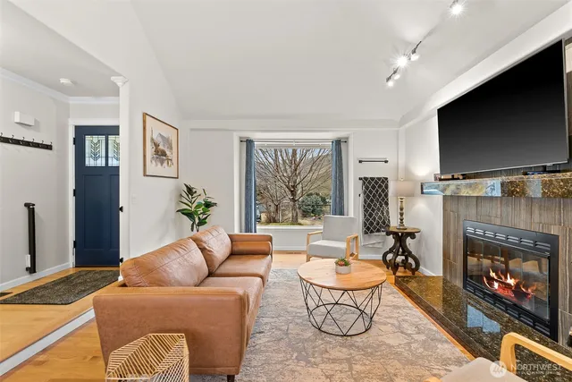 a living room with furniture a flat screen tv and a fireplace