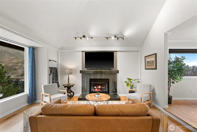 a living room with furniture a fireplace and a flat screen tv