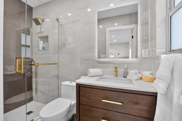 a bathroom with a sink a toilet and shower