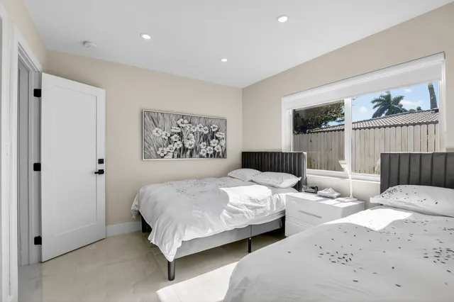 a bedroom with two beds and a large window