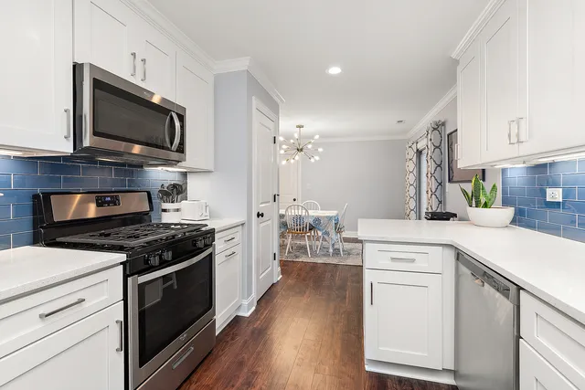 a kitchen with stainless steel appliances a stove microwave and cabinets